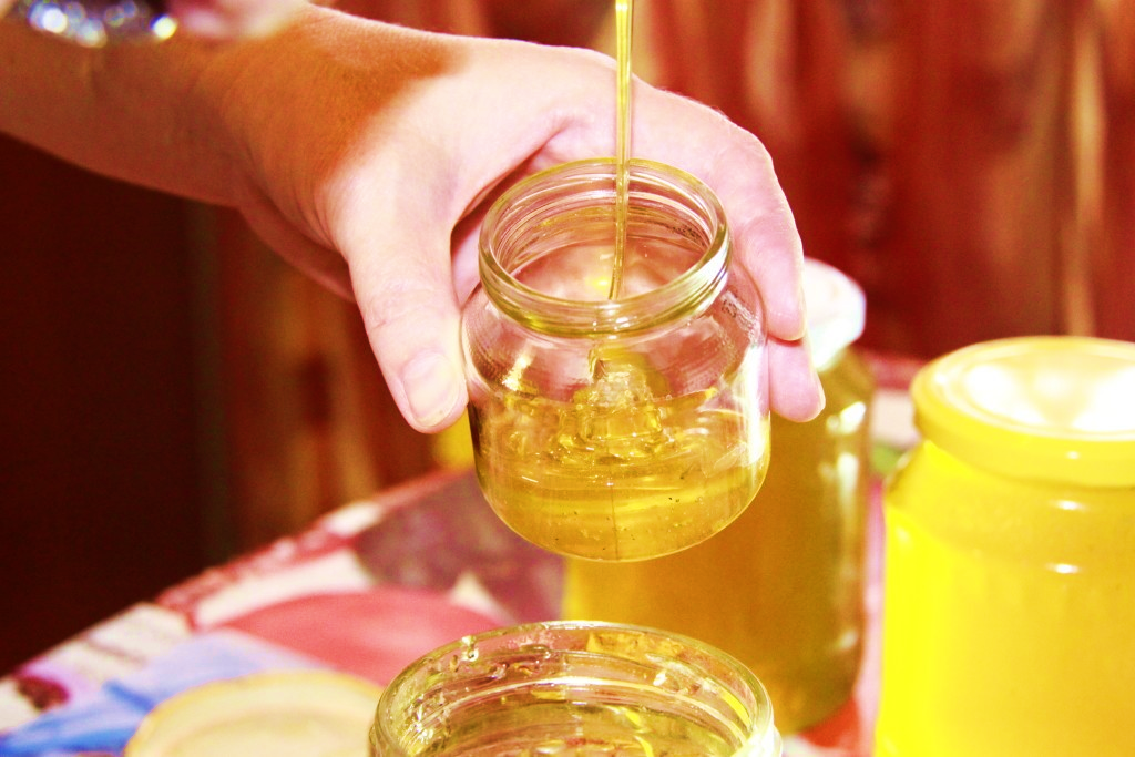натуральный жидкий мед наливают в стеклянную банку