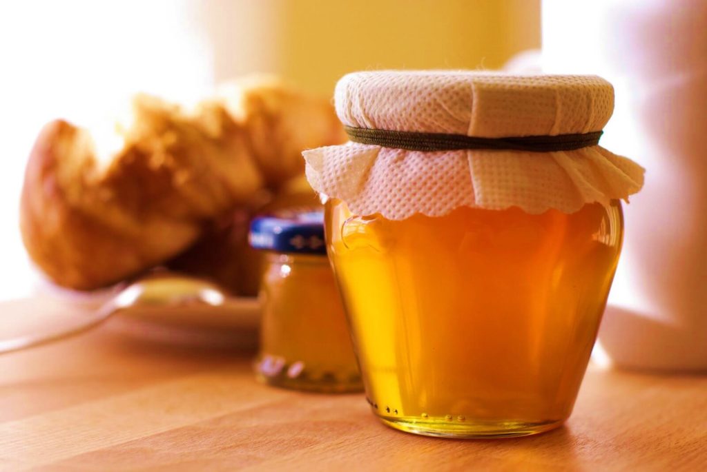 свежий мед в закрытой банке на столе
